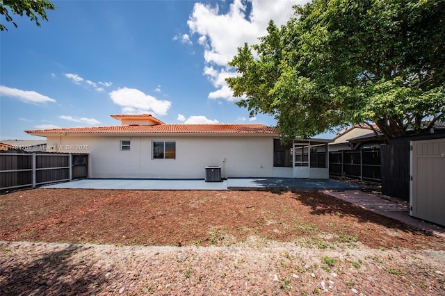 rear view of property featuring a sunroom, a patio area, fence, and a tiled roof