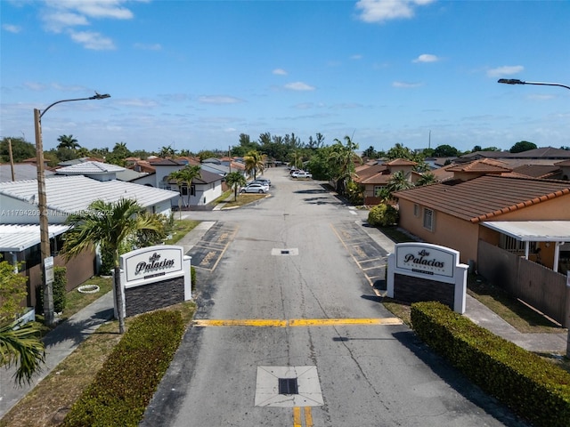 view of street featuring street lighting, sidewalks, and a residential view