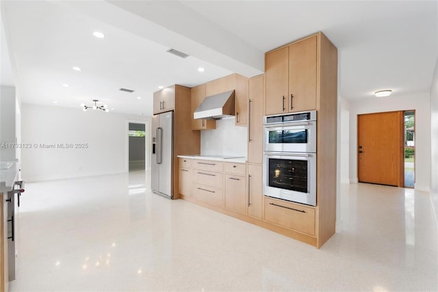 kitchen with visible vents, light brown cabinetry, high end fridge, wall chimney range hood, and double wall oven