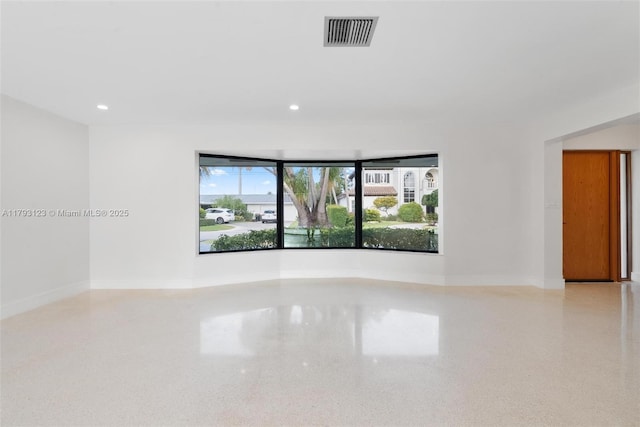 empty room featuring recessed lighting, baseboards, visible vents, and speckled floor