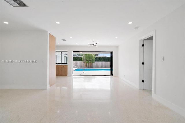 hallway with visible vents, recessed lighting, baseboards, and a notable chandelier