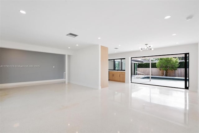spare room featuring visible vents, a sink, baseboards, a notable chandelier, and recessed lighting