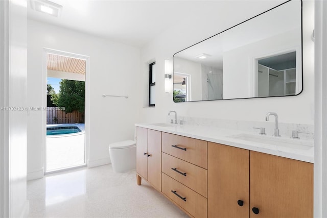 full bathroom with double vanity, a sink, a shower, and toilet