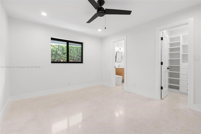 unfurnished bedroom featuring a walk in closet, baseboards, a closet, and recessed lighting