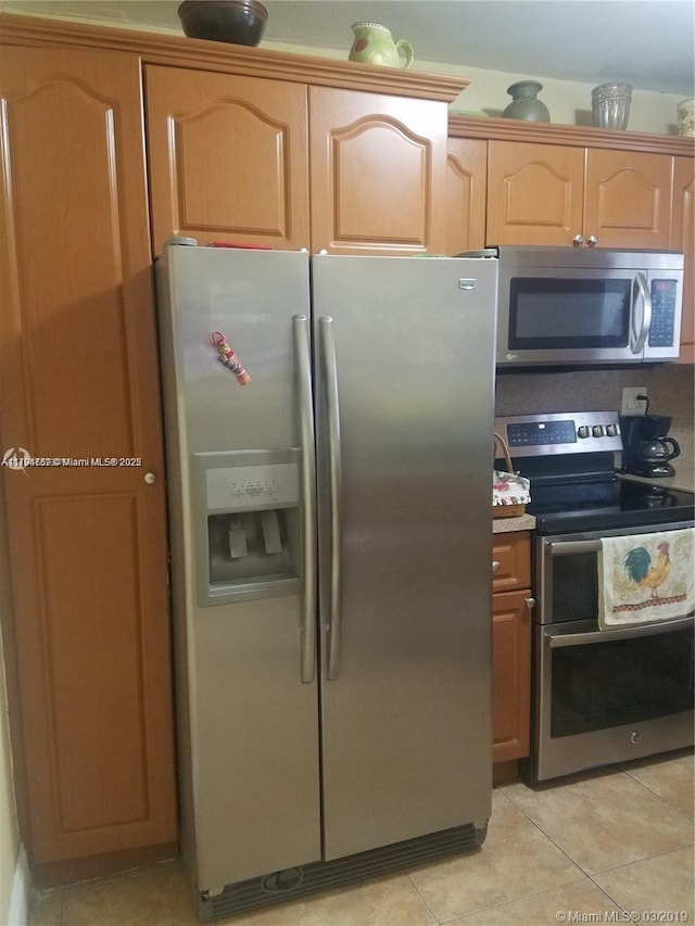 kitchen featuring light countertops, appliances with stainless steel finishes, and light tile patterned flooring