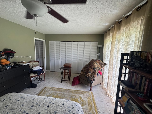 197 Kent L, West Palm Beach, FL 33417 - tiled bedroom featuring two closets, a textured ceiling, and ceiling fan