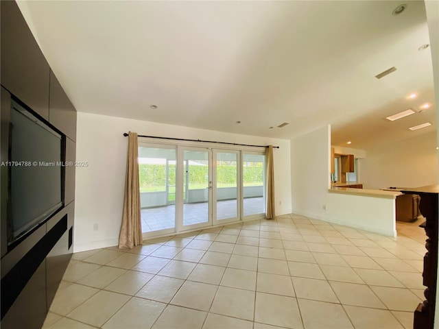 unfurnished living room featuring baseboards and light tile patterned floors