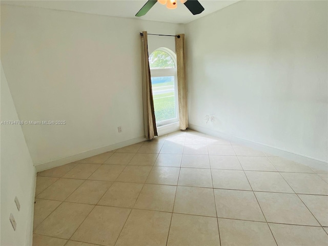 unfurnished room featuring baseboards, ceiling fan, and light tile patterned floors