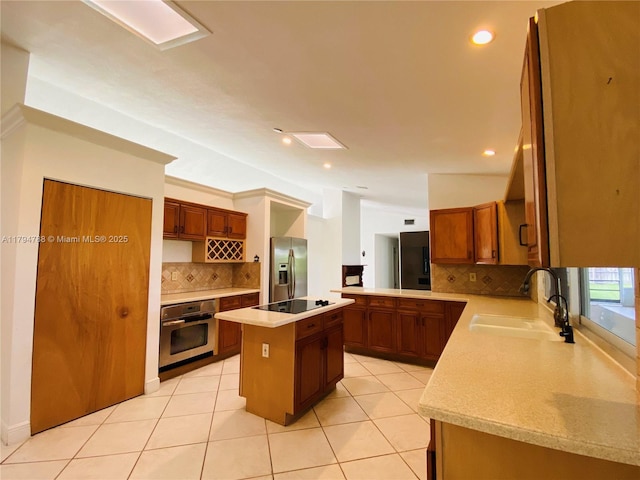 kitchen featuring a sink, appliances with stainless steel finishes, backsplash, and light countertops