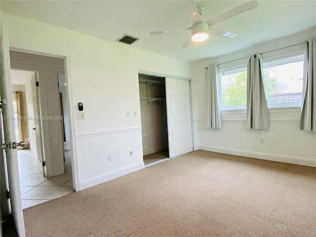 unfurnished bedroom with visible vents, a closet, light carpet, baseboards, and light tile patterned floors