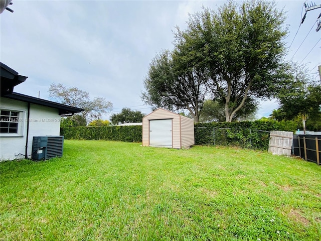 view of yard featuring a fenced backyard, an outbuilding, cooling unit, and a storage shed