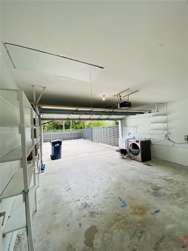 garage with washing machine and dryer and a garage door opener
