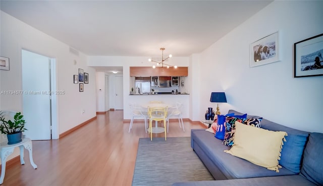 living area featuring an inviting chandelier and wood finished floors