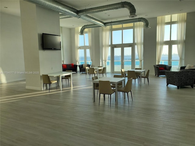 dining area with a high ceiling and wood finished floors