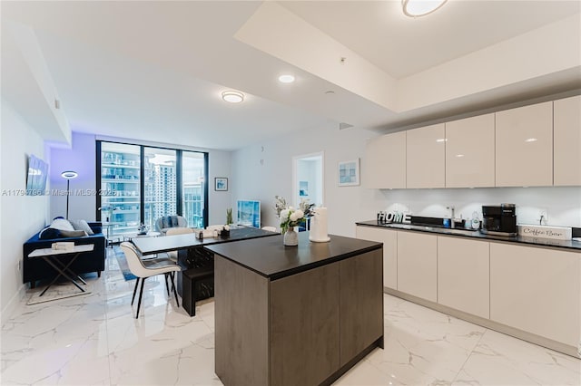 kitchen with dark countertops, marble finish floor, a center island, open floor plan, and modern cabinets