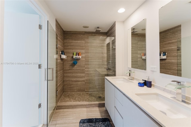 full bathroom with double vanity, recessed lighting, a sink, and a stall shower