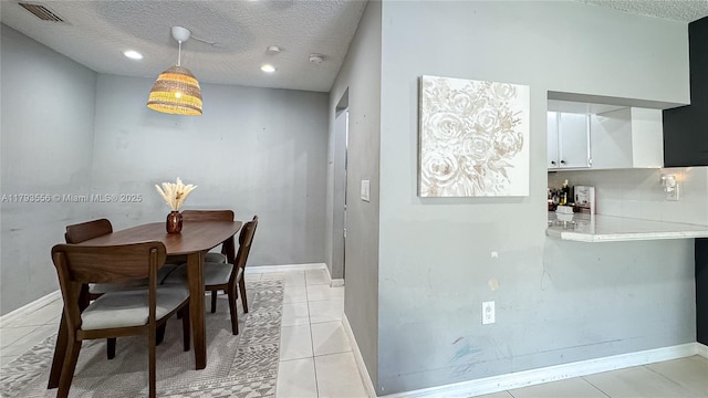 dining space featuring visible vents, a textured ceiling, and baseboards