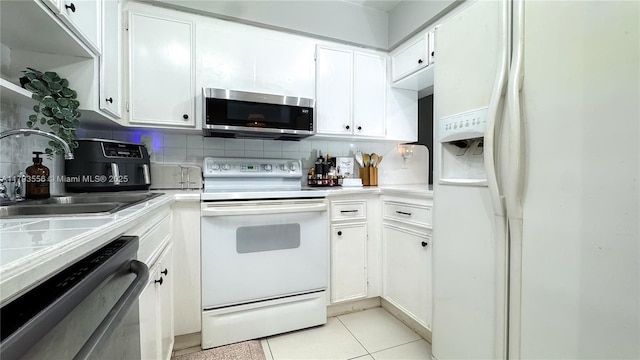 kitchen featuring a sink, white cabinetry, white appliances, and tasteful backsplash