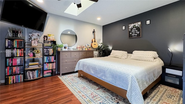 bedroom featuring recessed lighting, a ceiling fan, wood finished floors, and lofted ceiling with skylight