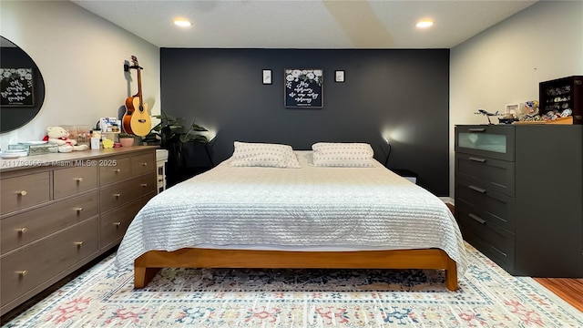 bedroom with recessed lighting and wood finished floors