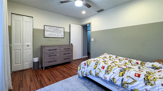 bedroom featuring a ceiling fan, a closet, dark wood finished floors, and visible vents