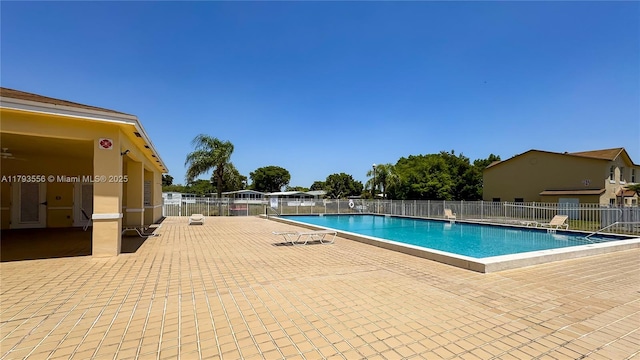 pool with a patio and fence