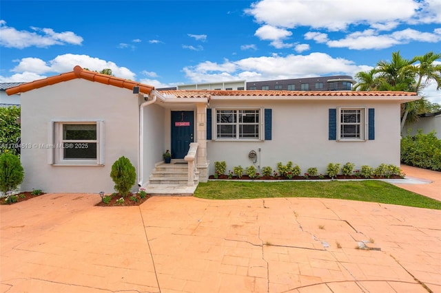 view of front of house featuring a tile roof and stucco siding