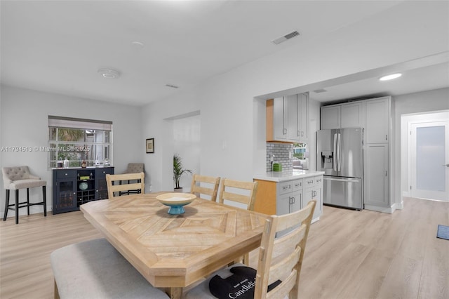 dining space with visible vents and light wood-style flooring