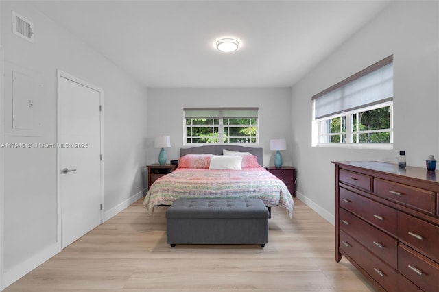 bedroom with visible vents, light wood-style flooring, baseboards, and multiple windows