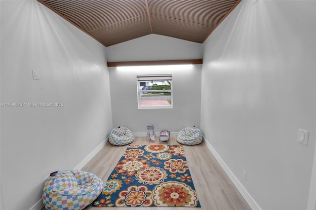 interior space featuring baseboards, wood finished floors, and lofted ceiling