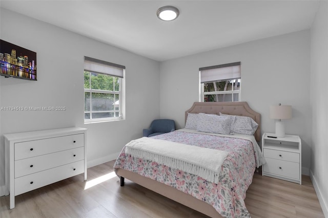 bedroom with light wood-type flooring and baseboards
