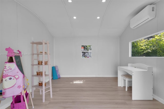 playroom featuring a wall unit AC, baseboards, lofted ceiling, recessed lighting, and light wood-style flooring