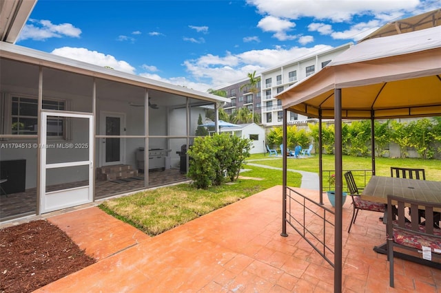 view of patio featuring a gazebo and a sunroom