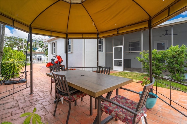 view of patio with fence, outdoor dining space, and a gazebo