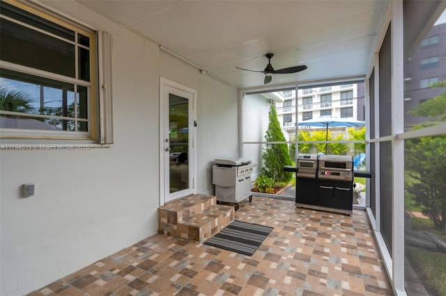 sunroom with ceiling fan and entry steps