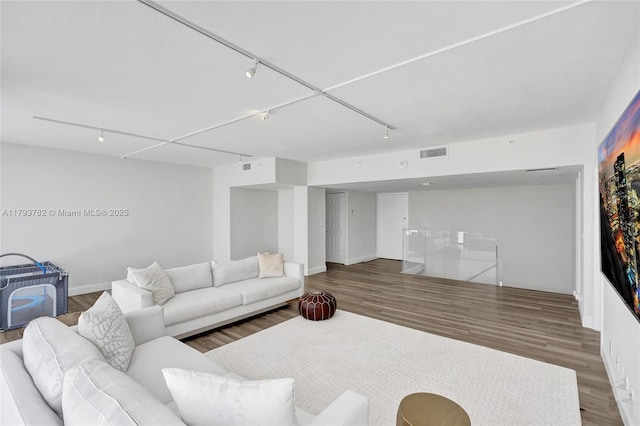 living room featuring visible vents, track lighting, and wood finished floors