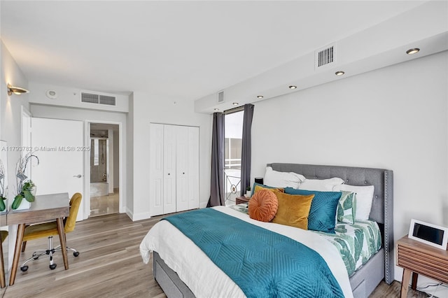 bedroom featuring visible vents, wood finished floors, and a closet