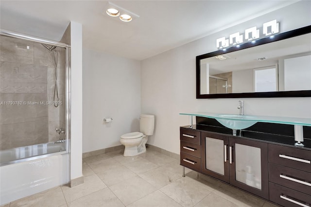 full bath with tile patterned flooring, baseboards, vanity, toilet, and shower / bath combination with glass door