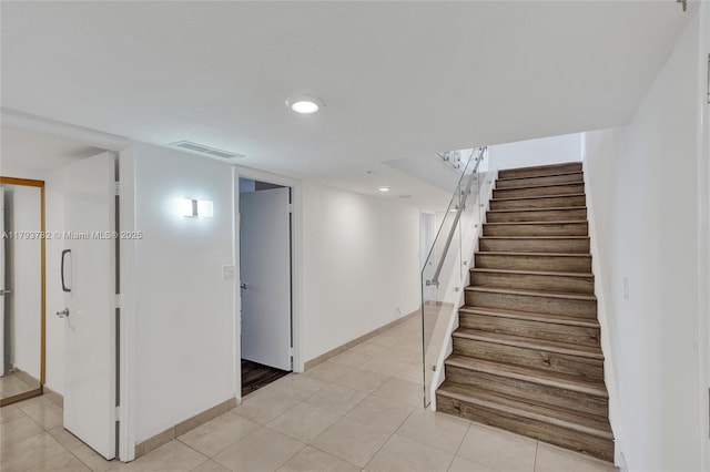 stairway featuring recessed lighting, baseboards, visible vents, and tile patterned flooring