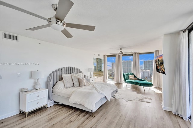 bedroom with ceiling fan, visible vents, access to exterior, light wood-type flooring, and baseboards