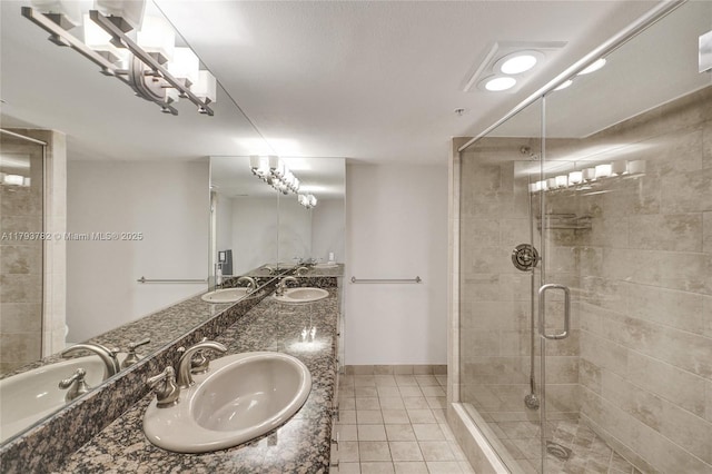 bathroom featuring a sink, tile patterned floors, and a stall shower
