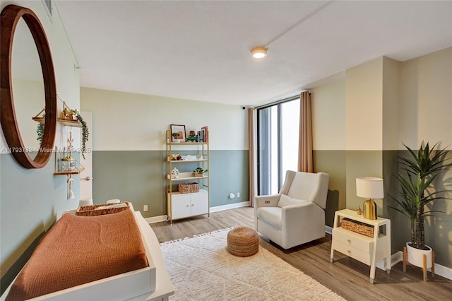 living area with baseboards and wood finished floors