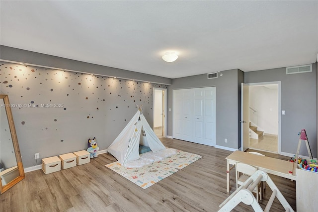 rec room featuring visible vents, baseboards, and wood finished floors