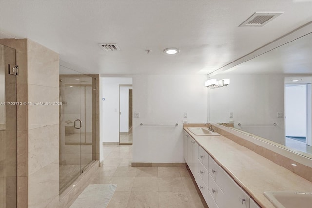 full bath with visible vents, a sink, double vanity, and a shower stall