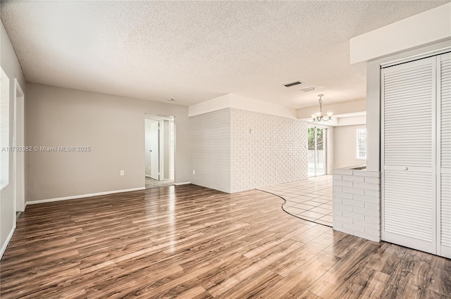 4109 NW 79th Ave, Coral Springs, FL 33065 - unfurnished room with a textured ceiling, a chandelier, wood finished floors, and visible vents