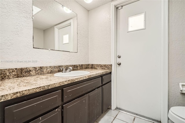 4109 NW 79th Ave, Coral Springs, FL 33065 - bathroom featuring a textured ceiling, vanity, tile patterned floors, toilet, and a textured wall