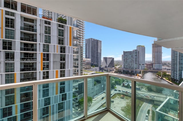 balcony featuring a water view and a city view