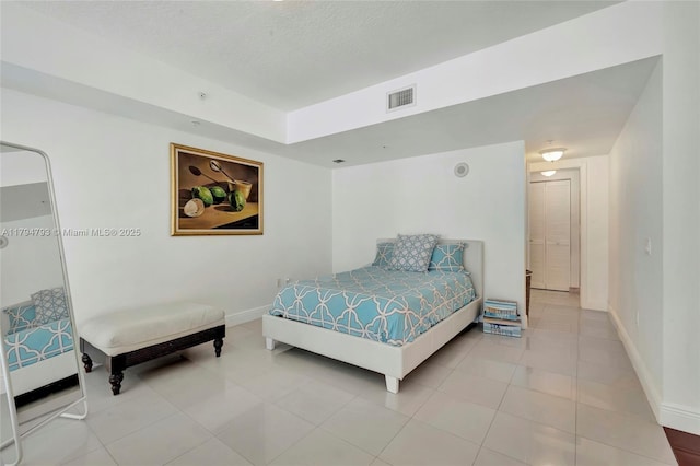 bedroom with light tile patterned floors, baseboards, and visible vents