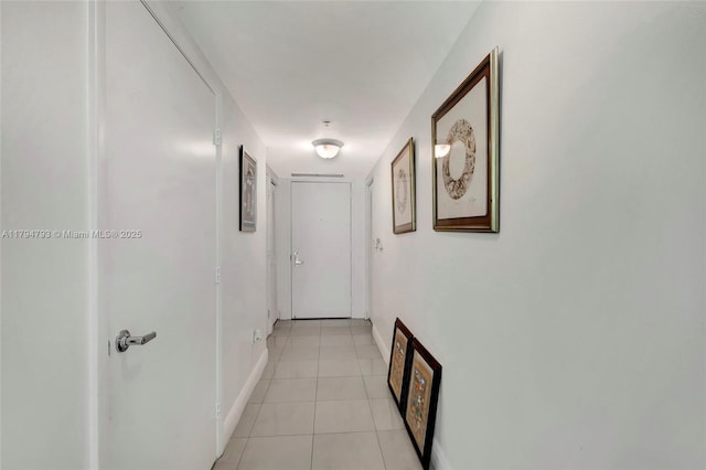 corridor with light tile patterned floors and baseboards