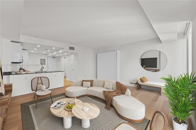 living room featuring recessed lighting, visible vents, and light wood-style flooring